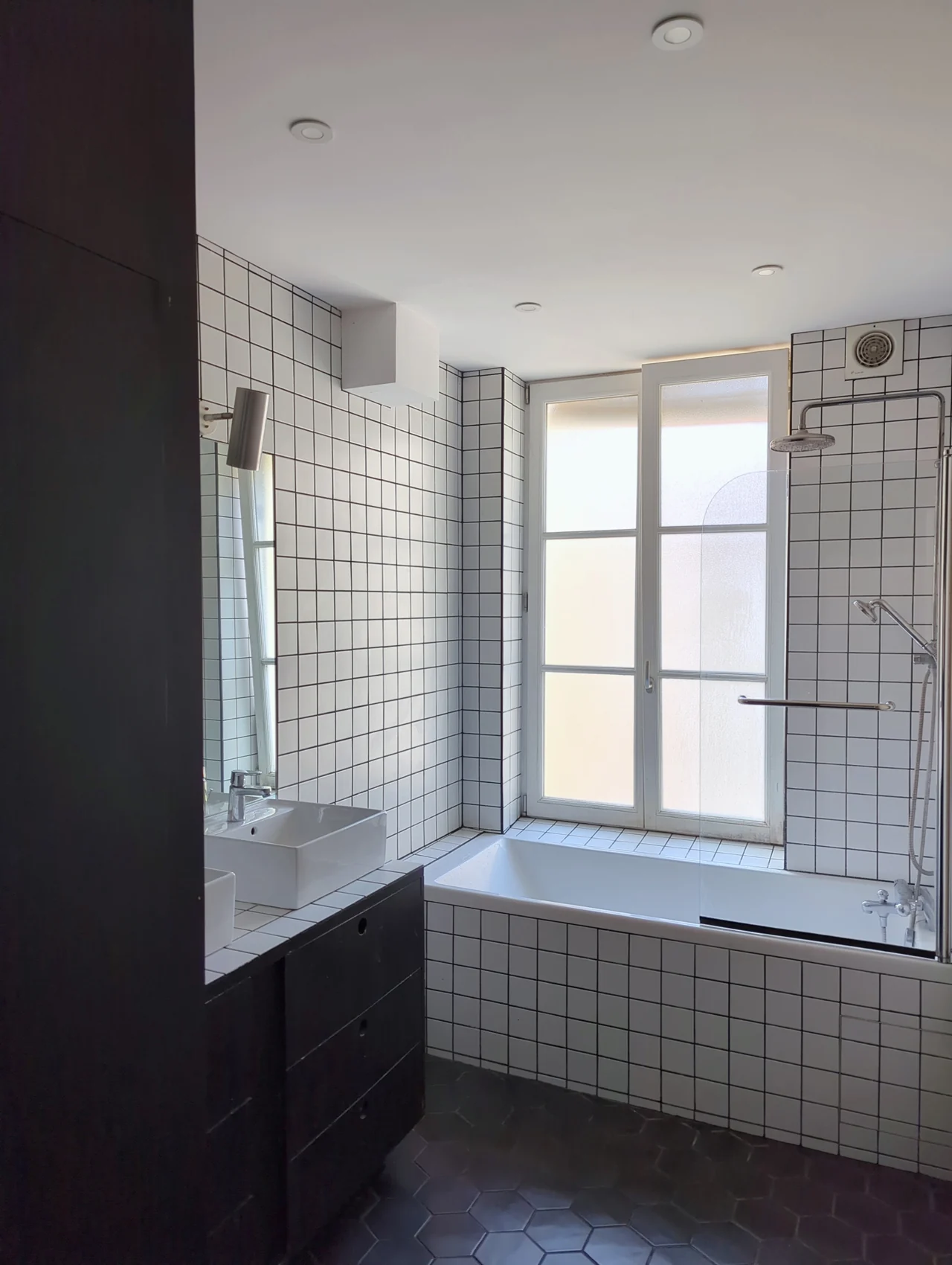 La salle de bain, côté baignoire et fenêtre